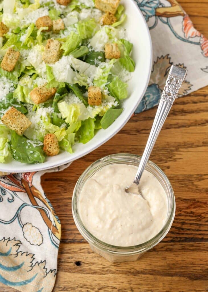 creamy caesar salad dressing in jar with spoon