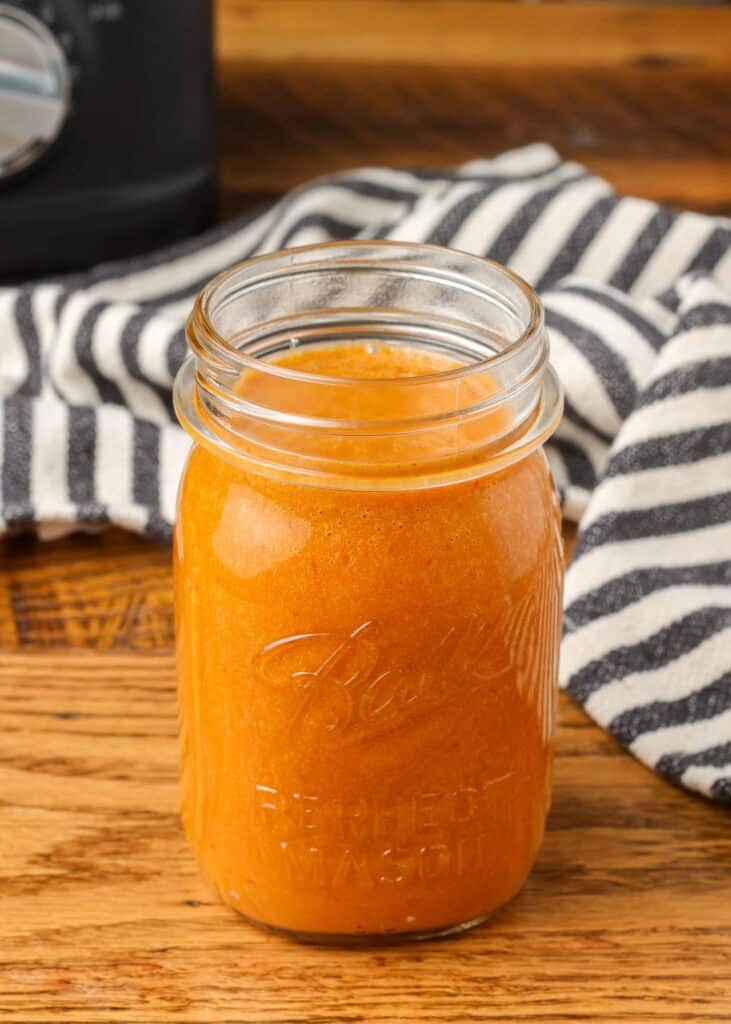 asian salad dressing in a mason jar with a striped linen