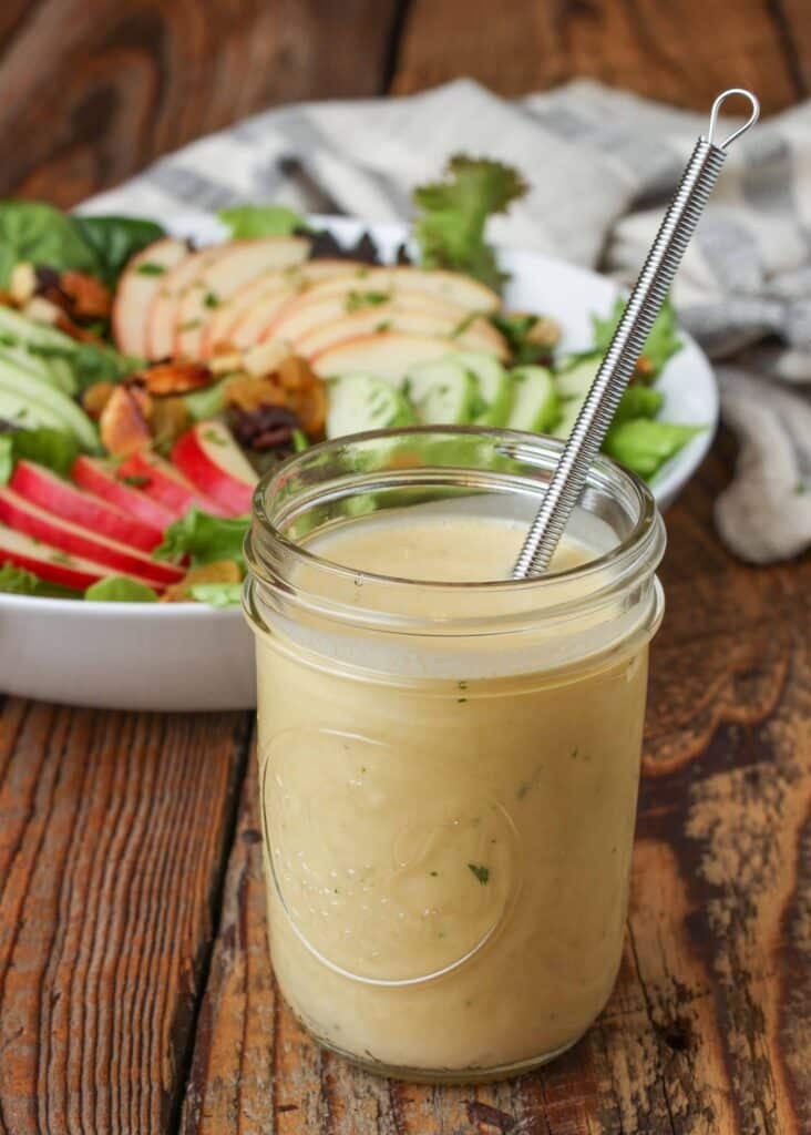 honey cider dressing in small jar with whisk