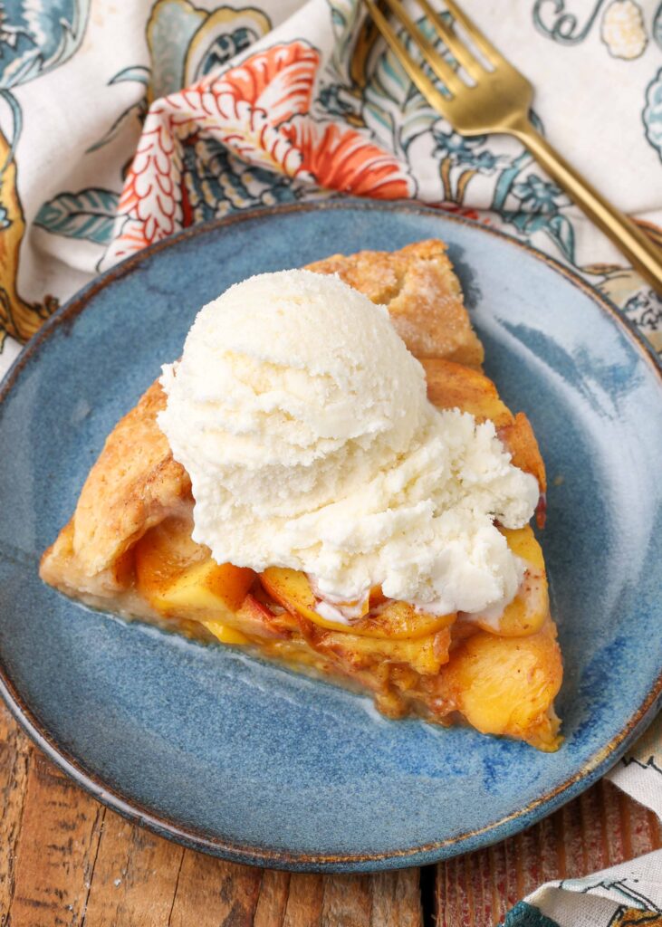 rustic galette with peaches sliced and served with ice cream