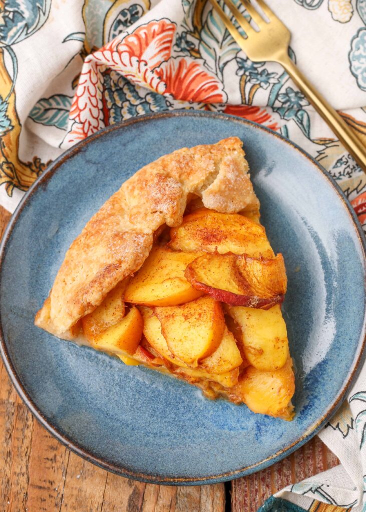 sliced peach dessert on blue plate with floral napkin