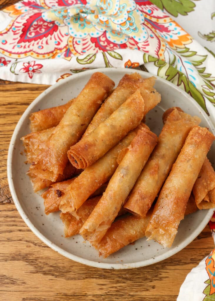 fried lumpia stacked on plate on wooden table