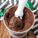 ice cream container with white scoop holding a portion of ice cream