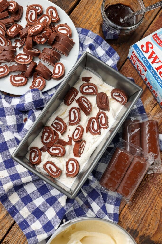 layering Swiss Rolls and chocolate sauce into ice cream