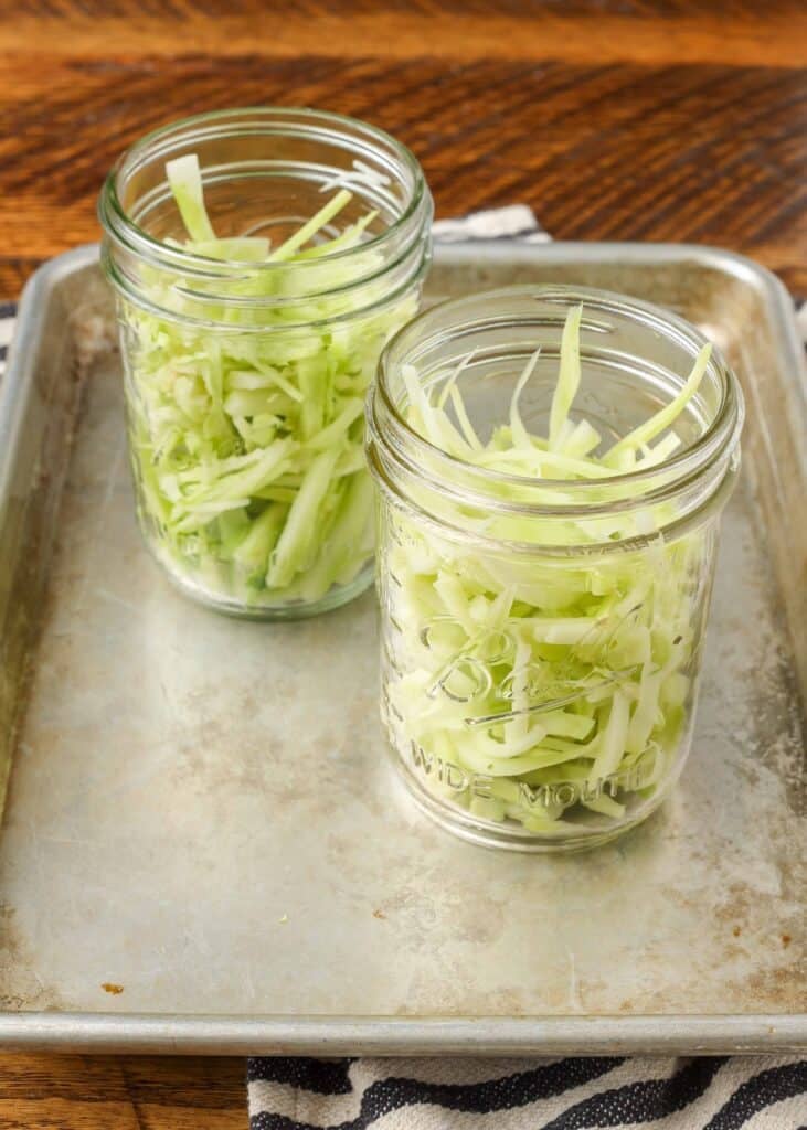 thinly sliced broccoli stems in two small jars