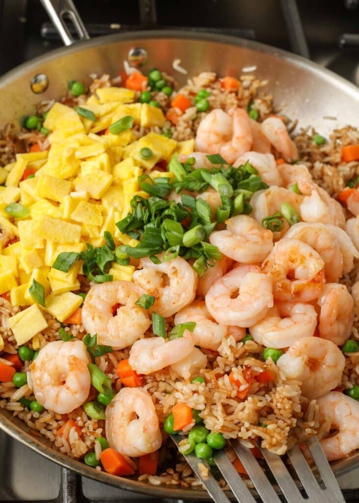 eggs and shrimp added to skillet with rice