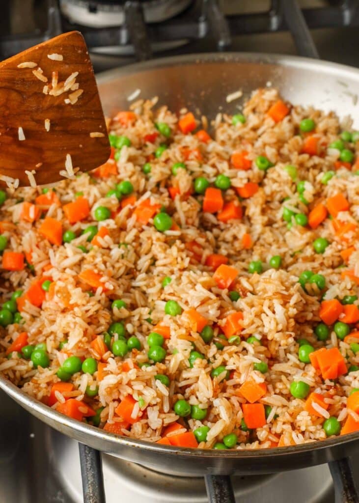 rice frying in skillet with vegetables