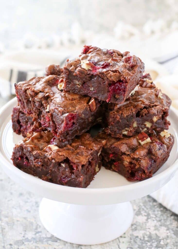 vertical shot of brownies stacked on plate next to white towel