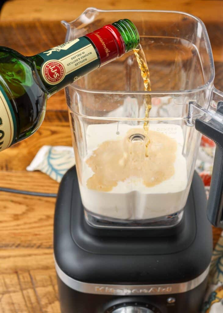 making homemade irish cream by a floral linen