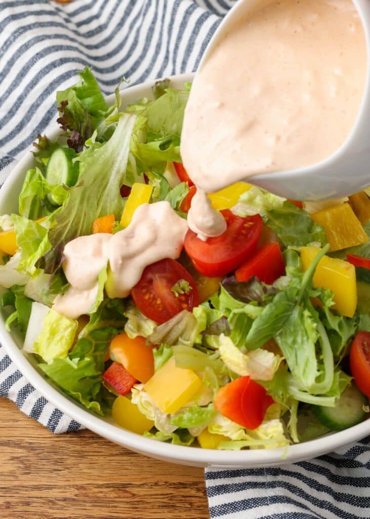 russian dressing in a salad dressing boat with a spout and a salad