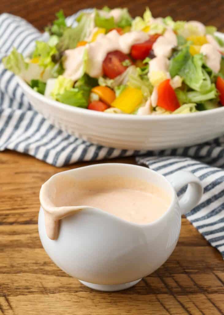 russian dressing in a salad dressing boat with a spout and a salad