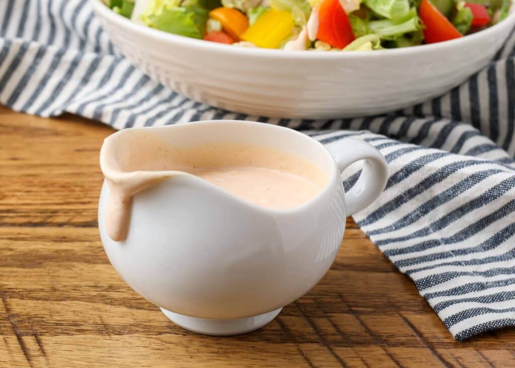 russian dressing in a salad dressing boat with a spout and a salad