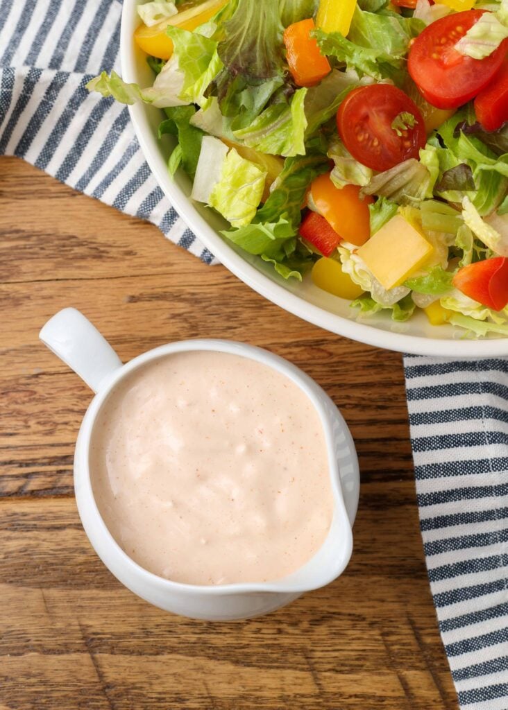 russian dressing in a salad dressing boat with a spout and a salad