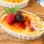 Creme brulee in a ramekin with berries and mint.
