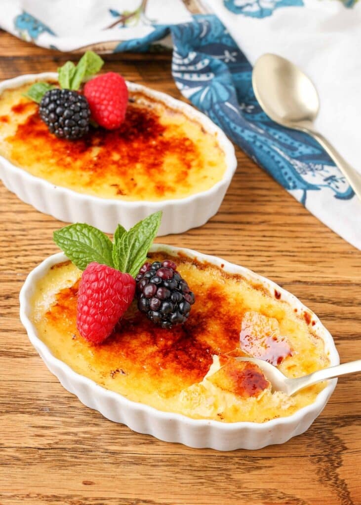 Creme brulee in a ramekin with berries and mint.