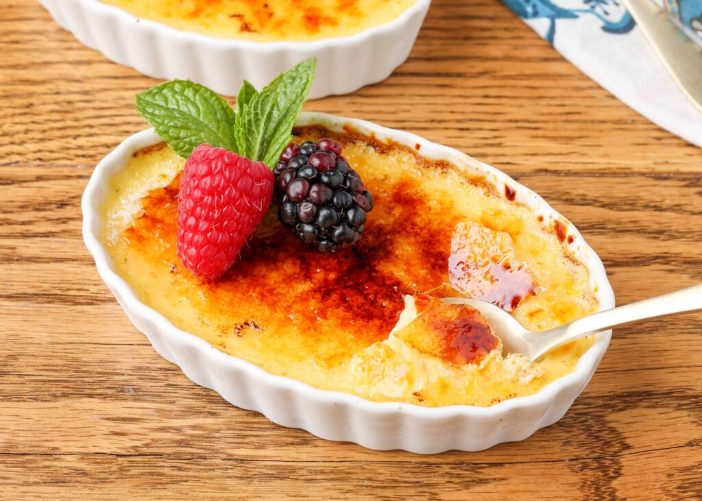Creme brulee in a ramekin with berries and mint.