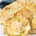 Sliced green cabbage on a plate that has been roasted.