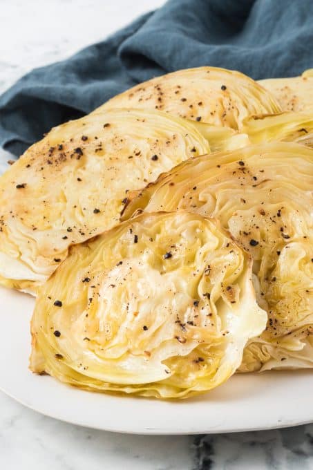 Sliced green cabbage on a plate that has been roasted.