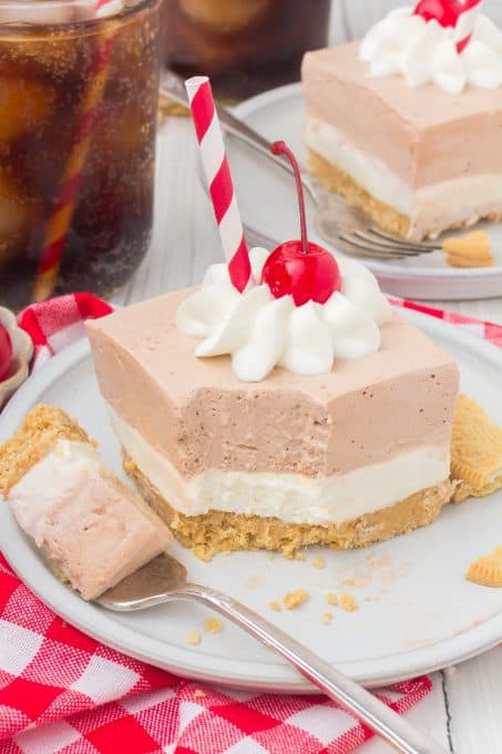 A bite taken our of a layered dessert on a plate.