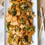 A plated Thai chicken recipe with noodles and broccoli rabe