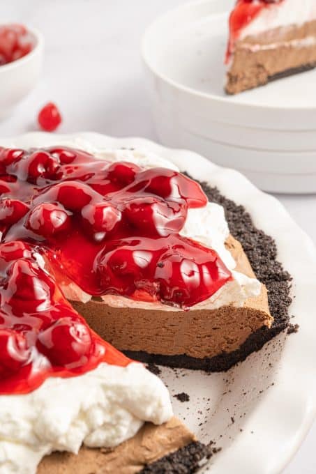 A no bake chocolate pie with whipped topping and cherry pie filling.