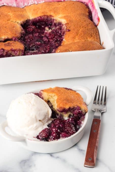 Ice cream tops a cobbler made with berries.