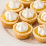 A plate of cookie cups filled with lemon curd with browned frosting.