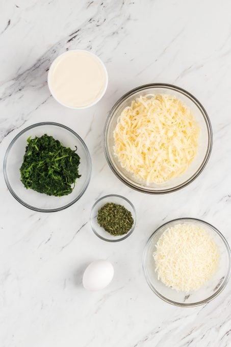 Cheese and spinach stuffed pasta shell ingredients in bowls.