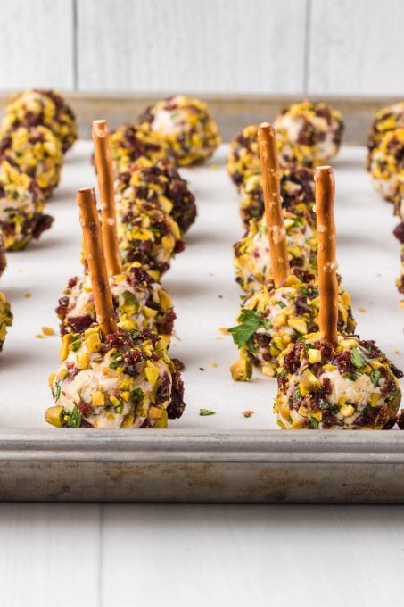 Bite size balls of cheese covered in chopped pistachios and dried cranberries for an easy appetizer.