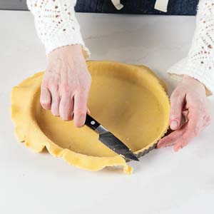 Trimming pie dough with knife