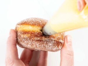 Putting filling in malasada