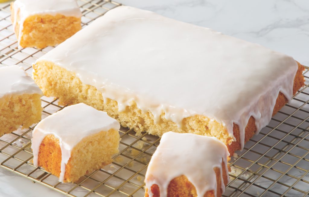 Lemon Snacking Cake with Lemon Glaze sliced on wire rack
