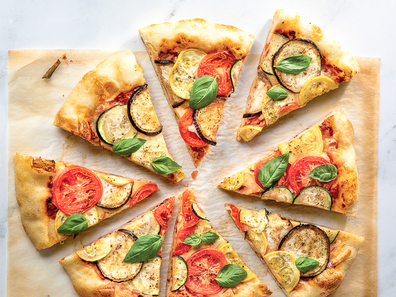ratatouille pizza sliced on parchment paper