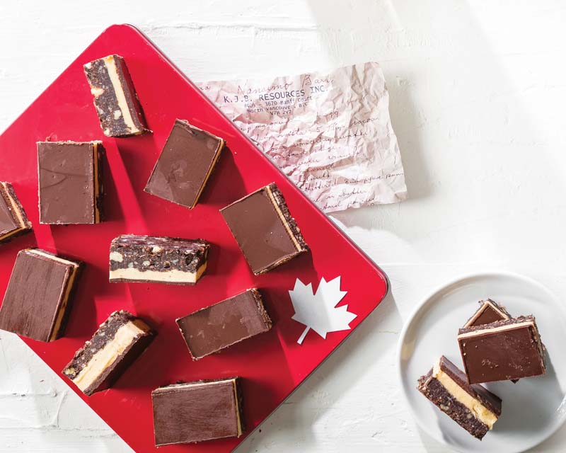 Eggnog Nanaimo bars on red Canadian platter with paper