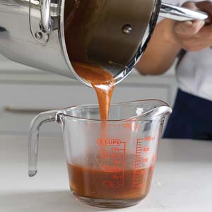 Pouring sauce into measuring cups
