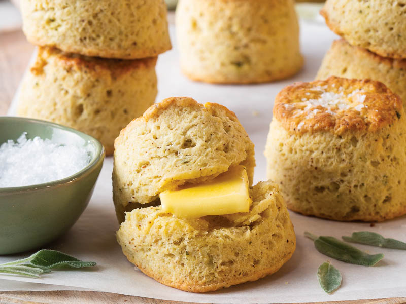 browned butter sage biscuits on parchment with a bowl of salt