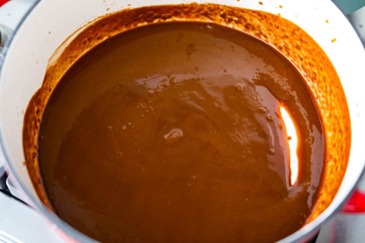 Roux ingredients browned and cooking in a pot.