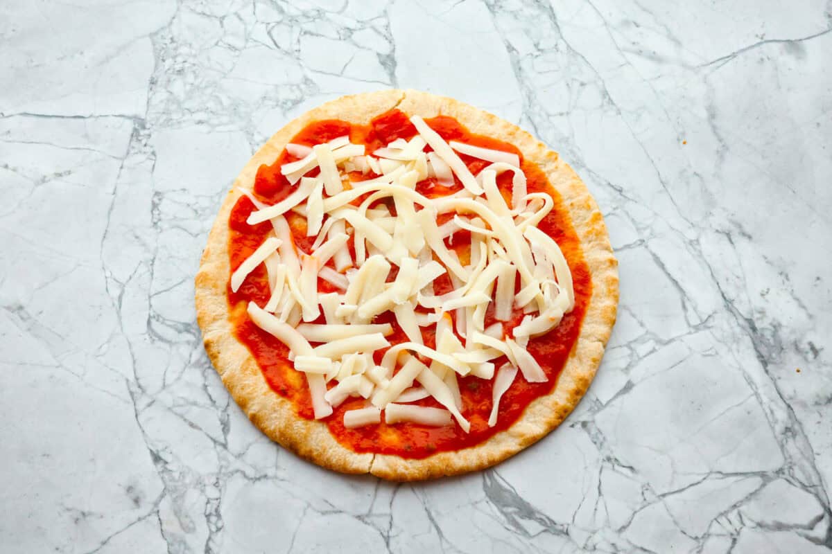 Overhead shot of pita with marinara and cheese spread on top. 