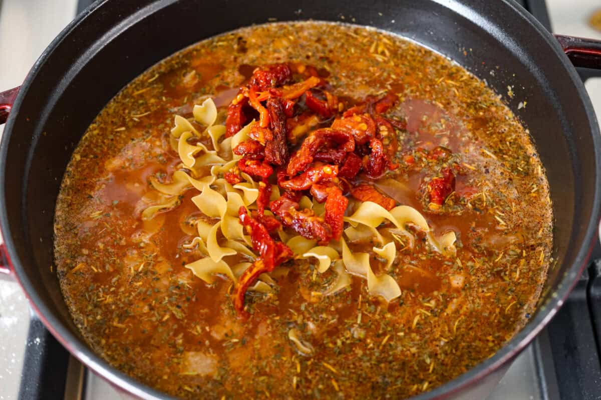 Fourth photo of the noodles and sun-dried tomatoes added to the pot.