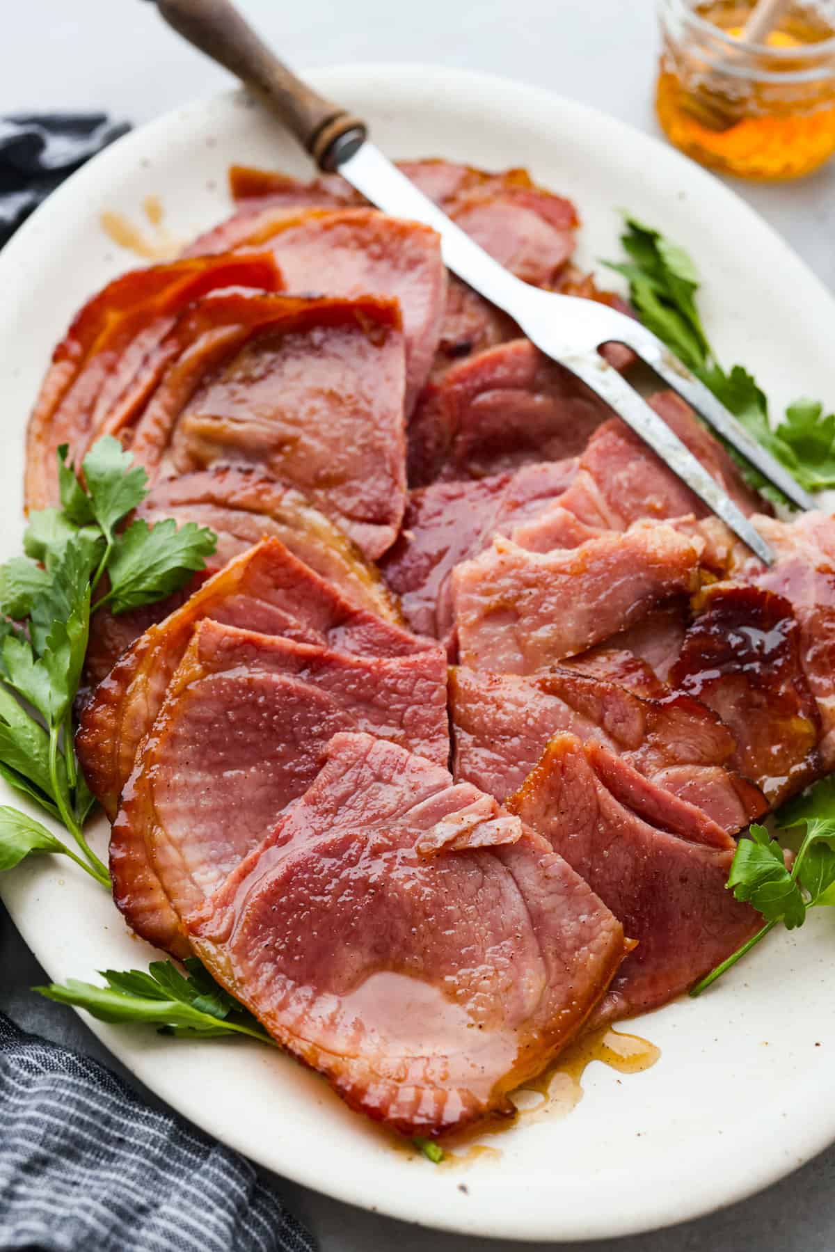 Christmas dinner can feel big, especially when you’re feeding a crowd and juggling gift budgets at the same time. This Christmas dinner menu keeps things cozy, classic, and doable so you can enjoy the day without overspending. Use the full lineup if you’re hosting, or just grab a side or dessert if you’re bringing something to share. Platter of honey ham for Christmas dinner.