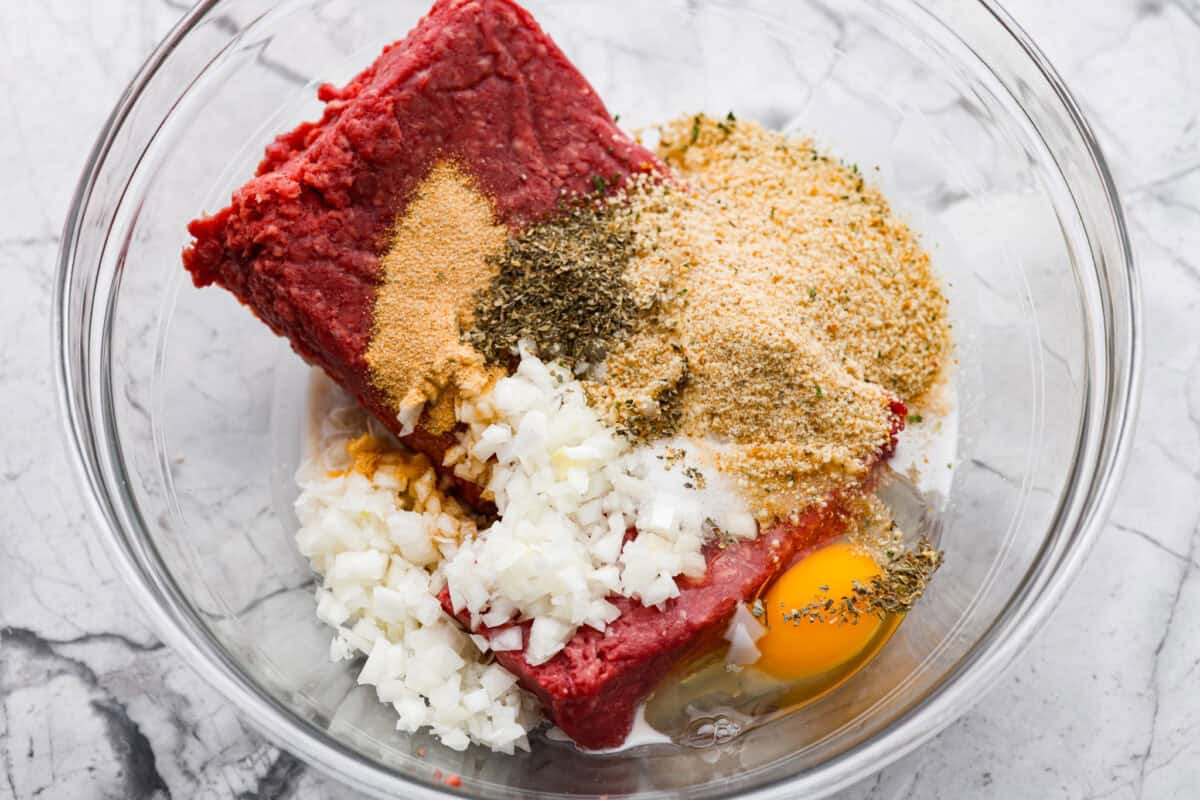 All of the meatloaf ingredients added to a bowl. 