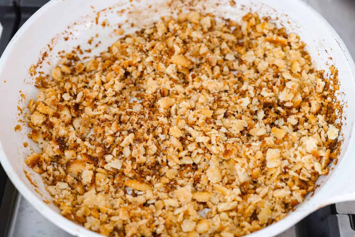 Butter and crushed Ritz crackers cooking on a skillet.