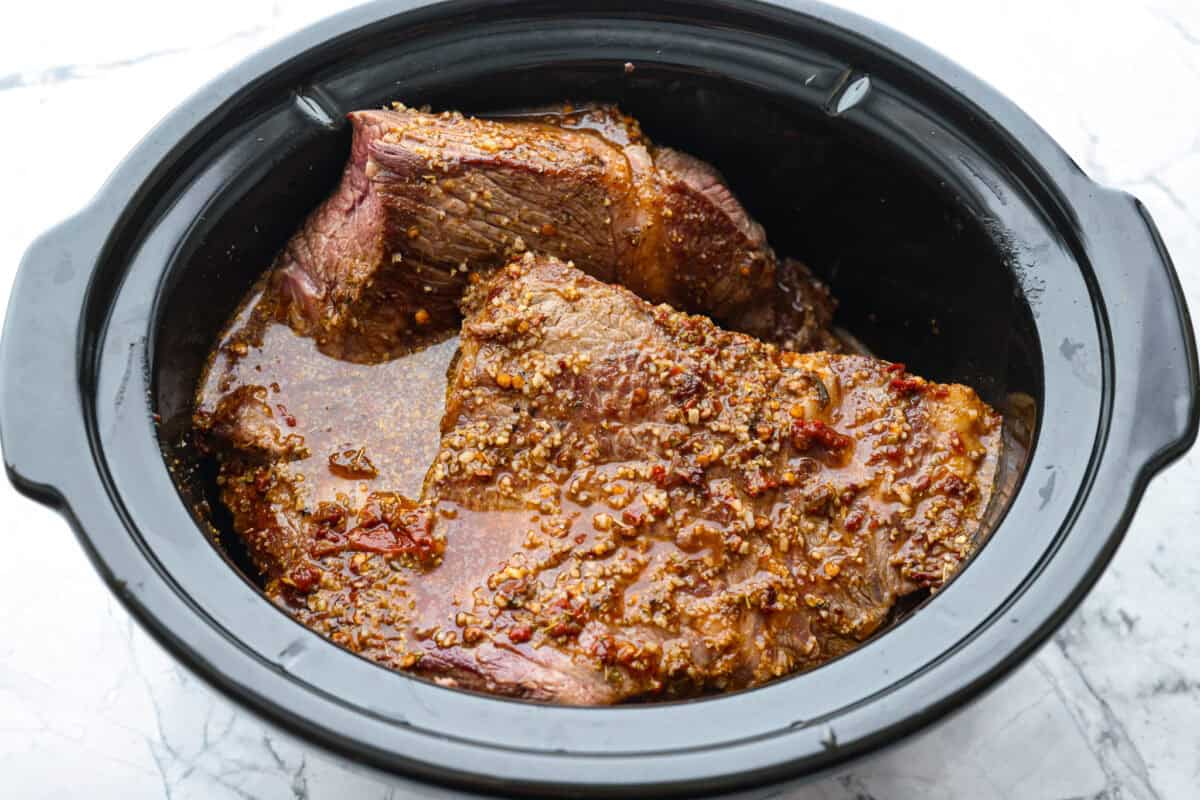 Sauce poured over the browned beef in the crockpot.