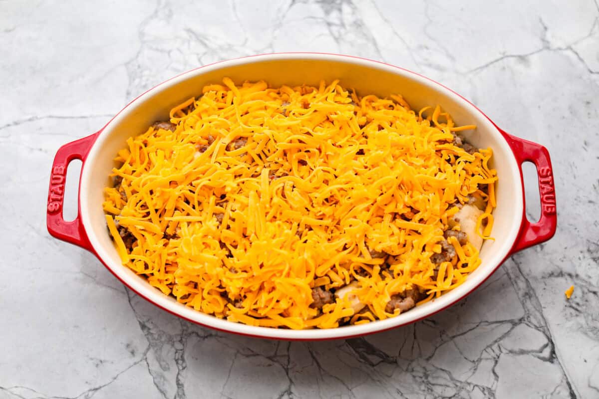 Cheese sprinkled over the top of the sausage and biscuits.