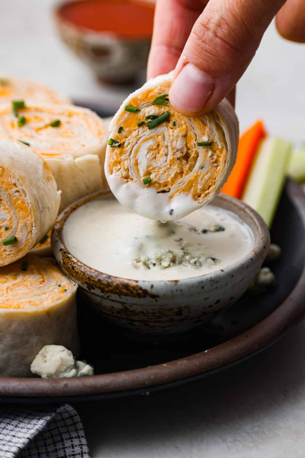 Close view of a pinwheel dipping into blue cheese dressing.