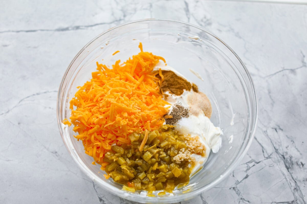 Cheese, chiles, and seasonings added to the bowl. 
