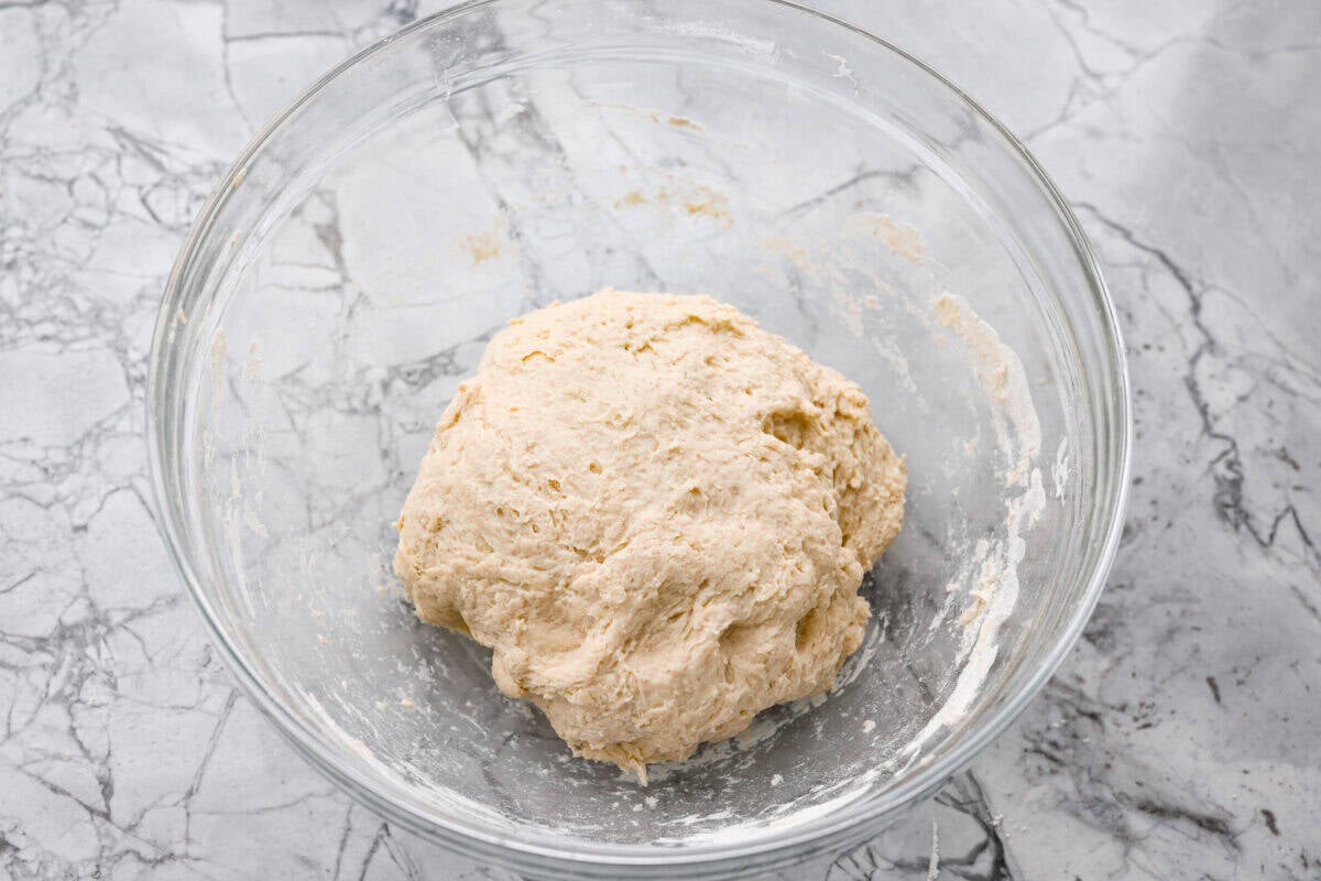 Dough combined and in a ball at the bottom of a bowl. 