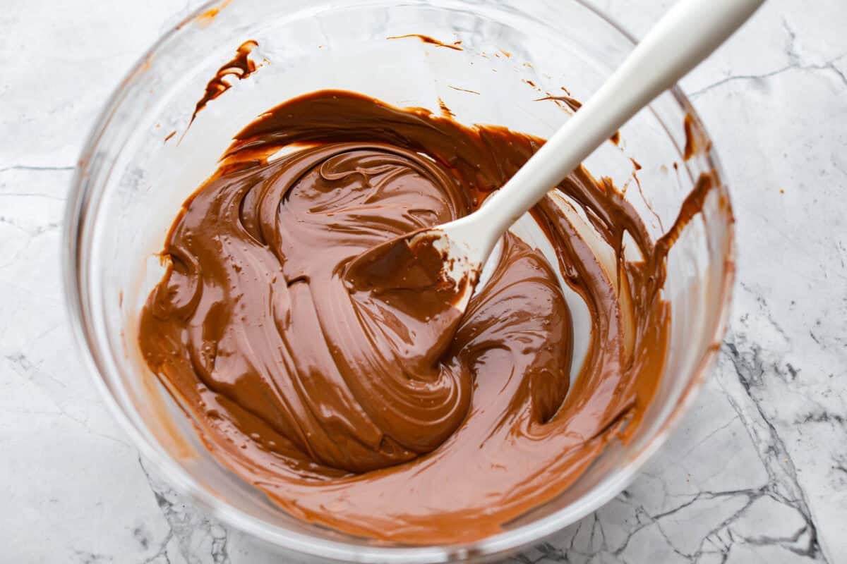 Melted chocolate stirred and smoothed out in a mixing bowl. 