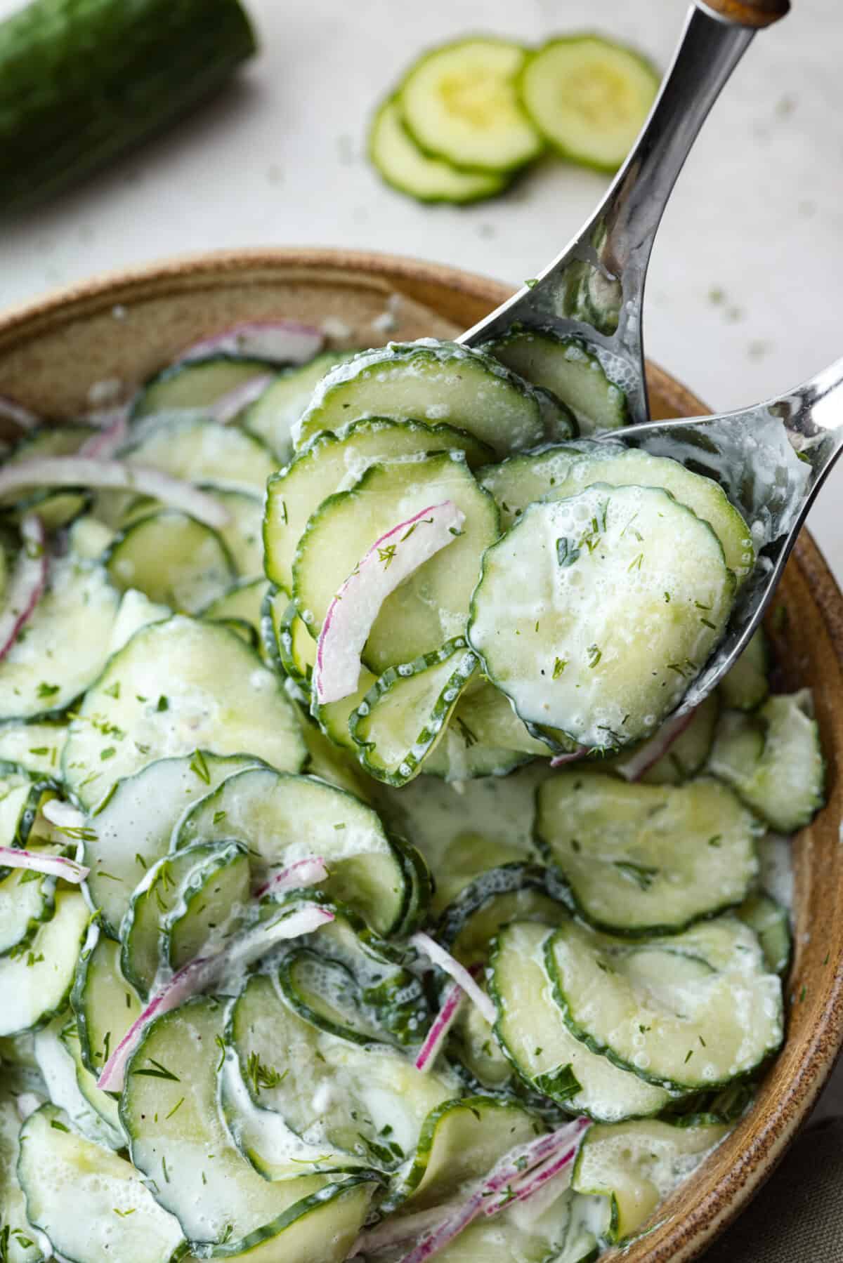 Close up shot of someone scooping some German cucumber salad 