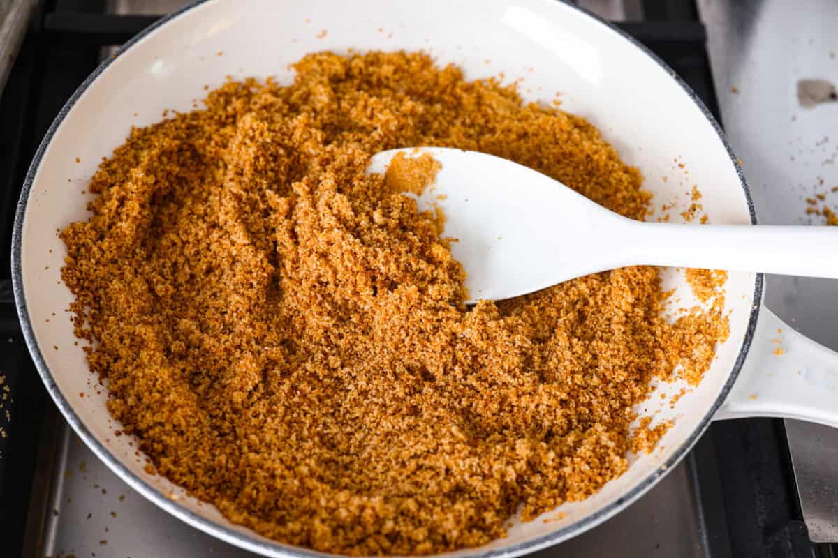 Breadcrumbs browning in a skillet on the stove top. 